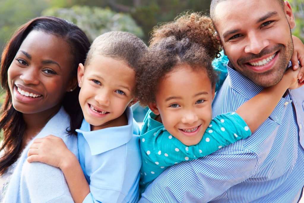 a man and two girls hugging each other.