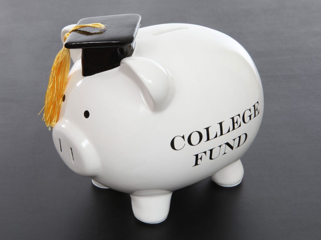 a white piggy bank with a graduation cap on top of it.