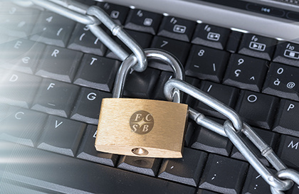 Keyboard with a lock and chain across the keys with FCSB logo. Shows importance of securing your information.